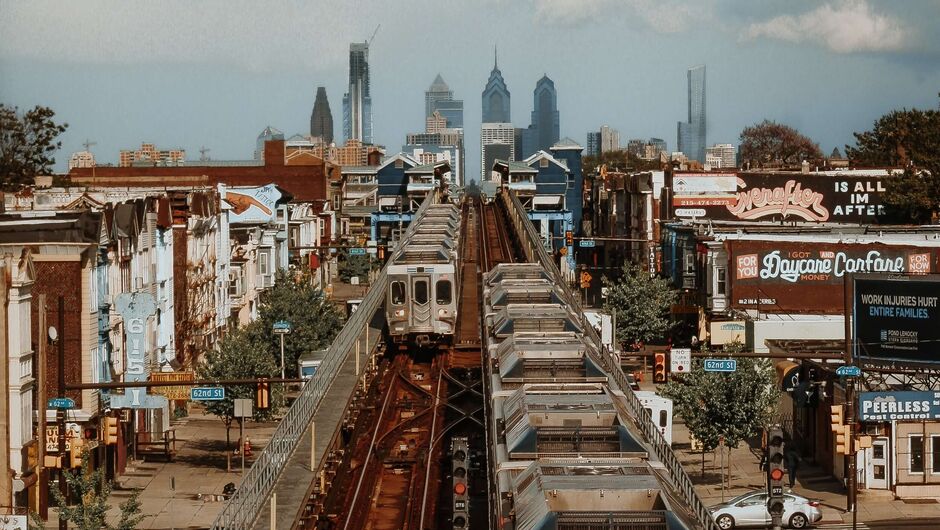 two above ground trains run through a neighborhood in philadelphia